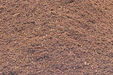 A closeup image of a large pile of mulch or wood chips use for landscaping top ground material and...