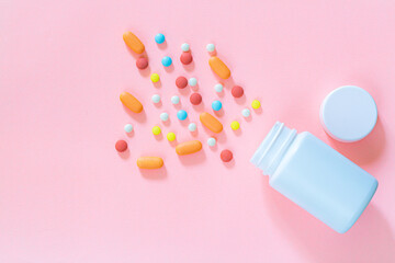 pills and pill bottles on pink background,Assorted pharmaceutical medicine pills, tablets and capsules and bottle on pink background. Top view. Flat lay. Copy space. Medicine concept. Heap of pills on