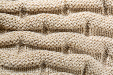 Fototapeta na wymiar texture of knitwear,Knitted background. Knitted wallpaper. Beige knitted fabric. Knitted texture. Soft material. Brown, beige and white handmade sweater close up photo. Cozy background. Knitwear detai