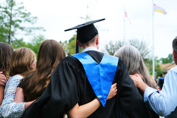 Family embraces recent high school graduate.