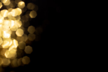 Fototapeta premium Golden blurred bokeh lights on black background. Glitter sparkle stars for celebrate. Overlay for your design