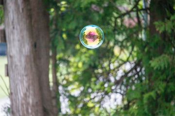 Bubble floating in the air ouside reflecting a house