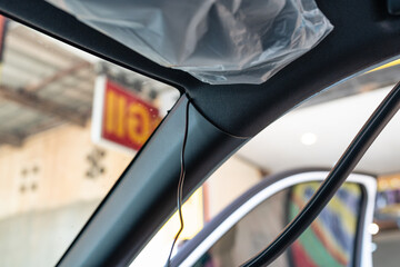 Installing wire of dash cam or video camera recorder in car frame at garage