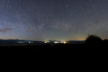 Beautiful bright milky way galaxy at the night sky and hills silhouette. Astronomical background.