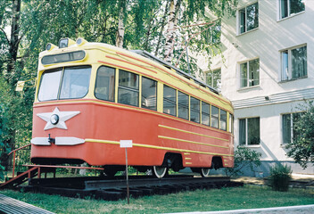 Fototapeta na wymiar old red retro tram in the museum under the sky photo taken on 35 mm film
