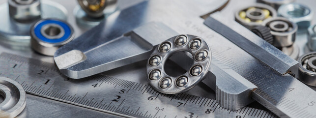 different bearings, vernier caliper and ruler on metal background. Part of mechanism.