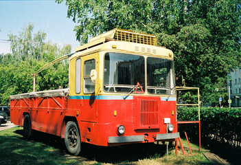 Fototapeta na wymiar red retro trolleybus with a cargo compartment for repair work on the line