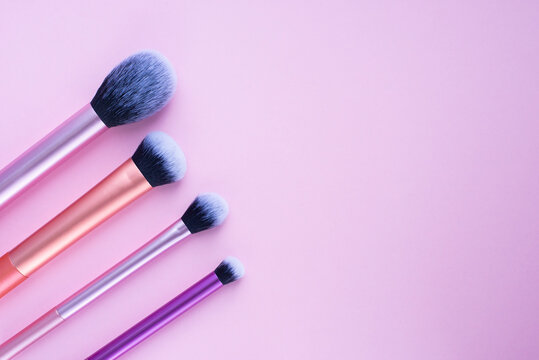 Professional makeup brush set for contouring and everyday makeup. Brushes for applying foundation, blush, powder and eyeshadow. Pink background with copy space for beauty and fashion sphere