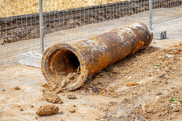 An old rusty cast-iron pipe of the city water pipe dug out of the ground during the repair of the...