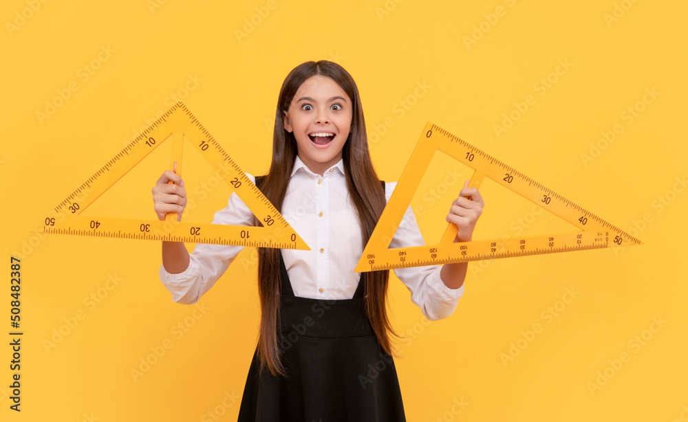 Wall mural amazed teen girl in school uniform hold mathematics triangle for measuring, high school