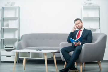 thinking mature businessman in suit sit in office with planner