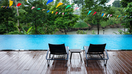 Swimming pool with background of tropical rainforest after raining.