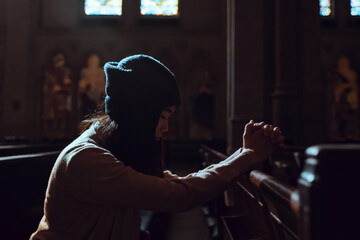 Young woman prayer's pray alone in church, People pray to God with folded hands, old wooden classic...