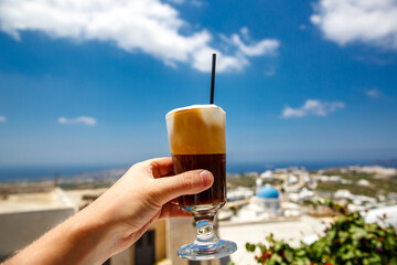 Frappe cold coffee in a hand on Santorini island in Greece