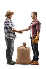 Full length profile shot of two farmers shaking