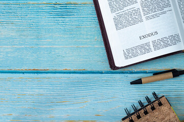 Exodus Bible Book on a wooden table with pen and notebook with copy space for text. Studying the...