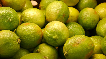 Close-up of many beautiful ripe limes in a trading box
