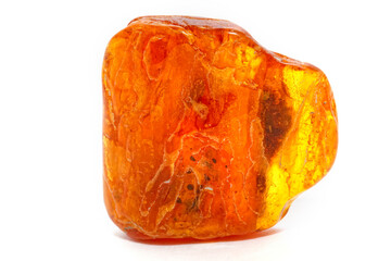 Yellow piece of amber on a white background. Natural mineral. Material for jewelry and ornaments. Sun stone. Science and geology. Fossilized resin. Semi-precious crystal