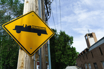 A yellow and black sign of a fire truck near the fire station