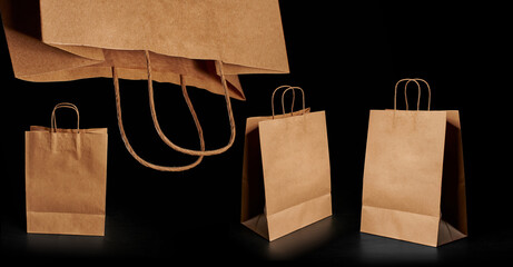 Image of different brown paper bags insulated on a black background. Craft bag with twisted handles.