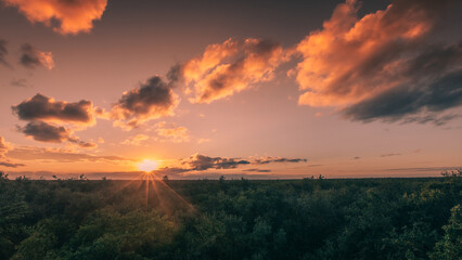 Sunset with light rays with warm light surrounded by tropical green jungle in Tulum on a cloudy afternoon