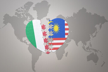 Obraz premium puzzle heart with the national flag of malaysia and italy on a world map background. Concept.