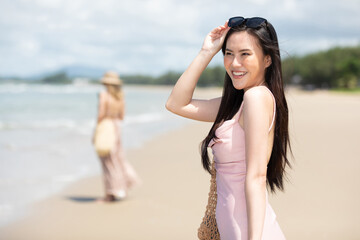 portrait young asian woman smiling and enjoy travel on the beach