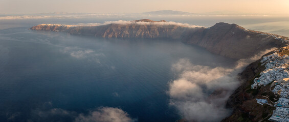 Santorini, Imerovigli and Oia villages on the cliff with famous caldera view, scenic aerial landscape with white architecture, Aegean Sea, sky with clouds and mist, outdoor travel background, Greece