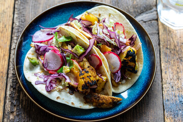 Tacos with spicy chicken, grilled pineapple and red cabbage salad