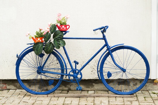 A blue bicycle with flowers used as a decoration outside a cafe
