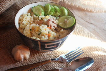Pork Fried Rice, Chinese Style Fried Rice in a Bowl with Cucumber and Lemon Served on a brown wooden table.
