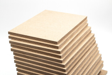A large number of raw mdf boards stand on top of each other.