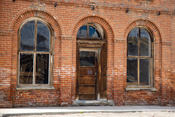 old brick building with wooden doors and windows