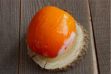frozen persimmons on a wooden background