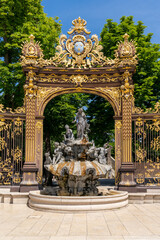 view of a gilded wrought-iron gate and Rococo fountain in the Stanislas Square of Nancy