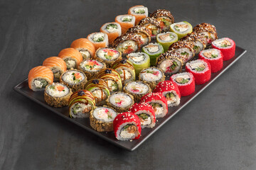 Sushi set. Roll with fresh ingredients on stone background.