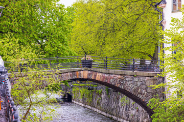 Fototapeta na wymiar View of old bridge across river on spring day. Europe. Sweden. Uppsala.