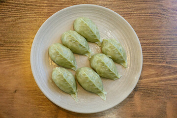Delicious looking dumplings in a bowl on a wooden table