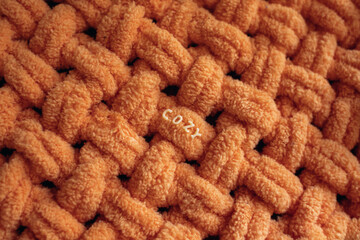 Plush plaid. Soft yarn for knitting. Cozy knitted background. Knit by hand. Home comfort. Handmade product. Women's hobby. Yarn texture.