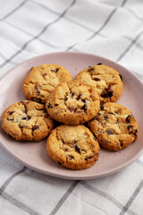 Homemade White Chocolate Cranberry Cookies on a Pink Plate, low angle view.