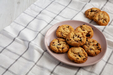 Homemade White Chocolate Cranberry Cookies on a Pink Plate, low angle view. Copy space.