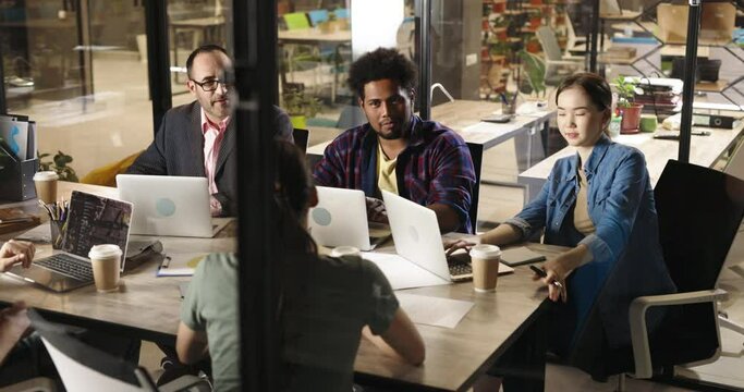 Millennial hipster employees discussing marketing strategies with diverse multiethnic team on brainstorming session in office. Creative workers on workshop 4k footage