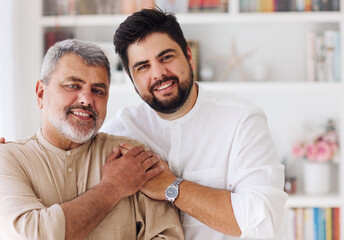 portrait of cheerful laughing adult father and son at home