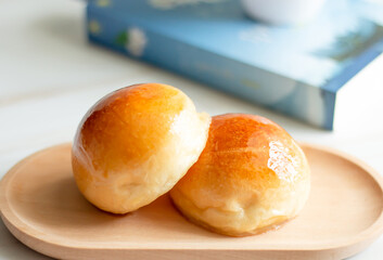Two butter bread bun  on wooden plate with book