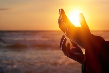 Plakat Silhouette human hands open palm up on sunset beach. Christian praying concept