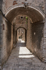Sibenik, Croatia - May 26, 2022 - narrow old street and yard in Sibenik city, medieval zone