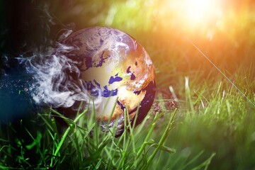 Earth planet globe with smoke on grass. Bad climate concept. overabundance CO2 on Earth. Elements by NASA. - obrazy, fototapety, plakaty