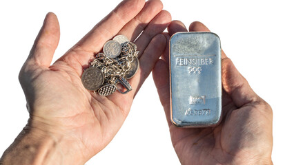 Silver bullion 1 kilo and old silver coins and jewelry in the hands isolated on white. feinsilber...