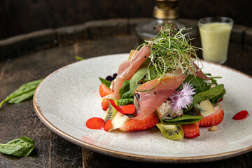 Salad with strawberries, parmesan and prosciutto. 