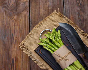 Bunch of fresh raw asparagus on a wooden black kitchen board, a healthy product